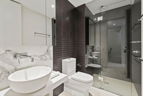 a bathroom with a sink and a toilet and a shower at Beautiful 1-Bed Unit in The Heart of Melbourne in Melbourne
