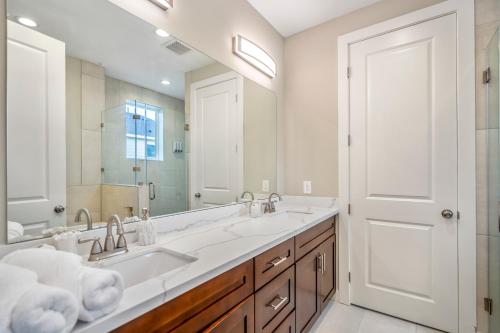 baño con 2 lavabos y espejo grande en Spacious 3 Bed House near MD Anderson with Free Parking & Wi-Fi en Houston
