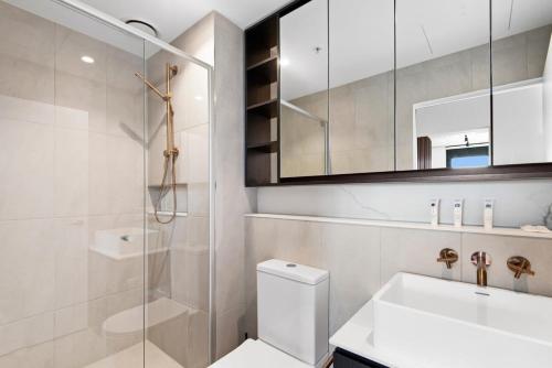 a bathroom with a shower and a toilet and a sink at Executive 2-Bed Apartment with Views, Gym and Pool in Melbourne