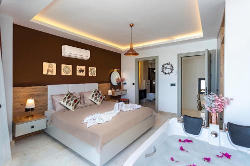 a bedroom with a large bed and a bath tub at Tashan Villas in Kas