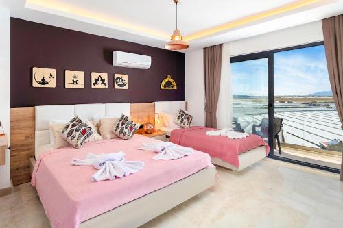 a bedroom with two beds with pink sheets at Tashan Villas in Kas
