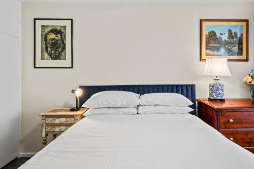 sypialnia z dużym białym łóżkiem i szafką nocną w obiekcie Snug 1-Bed Unit near Essendon Football Grounds w Melbourne