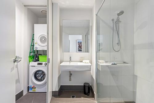 łazienka z umywalką i pralką w obiekcie Pristine 2-Bed Unit With Beautiful City Landscape w Melbourne