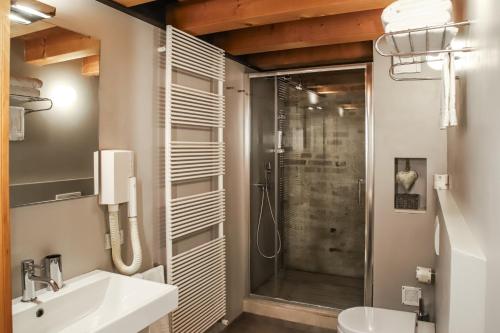 een badkamer met een douche, een wastafel en een toilet bij Locanda Ponte Dante in Treviso