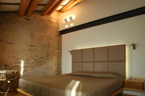 a bedroom with a bed and a brick wall at Locanda Ponte Dante in Treviso