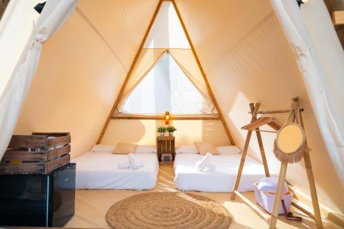 Una habitación con 2 camas en una tienda en Kampaoh Lago de Arcos, en Arcos de la Frontera