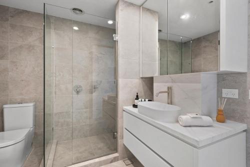 a bathroom with a toilet and a sink and a shower at Bespoke 2-Bed Beachfront Apartment in Melbourne