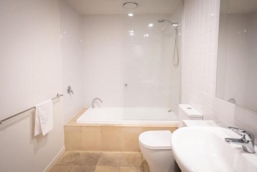 a bathroom with a tub and a toilet and a sink at Modern 2-Bed Apartment in Melbourne's Heart in Melbourne