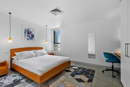a bedroom with a bed and a desk and a chair at Vibrant 2-Bed Apartment Near St Kilda Beach in Melbourne