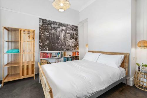 a bedroom with a bed and a book shelf at Refined 2-Bed House with a Charming Courtyard in Melbourne