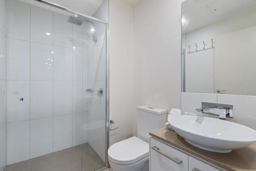 W łazience znajduje się toaleta, umywalka i prysznic. w obiekcie Elegant 2-Bed with Large Balcony by High Street w Melbourne