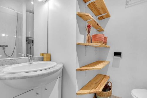 une salle de bain blanche avec un lavabo et un miroir dans l'établissement Joli studio rénové avec terrasse, à Toulouse