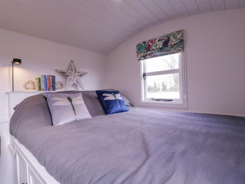 a bedroom with a large bed with a window at Bumble's Retreat in Whepstead