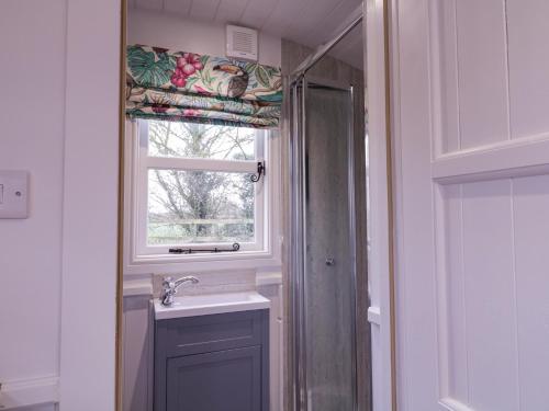 a bathroom with a sink and a window at Bumble's Retreat in Whepstead