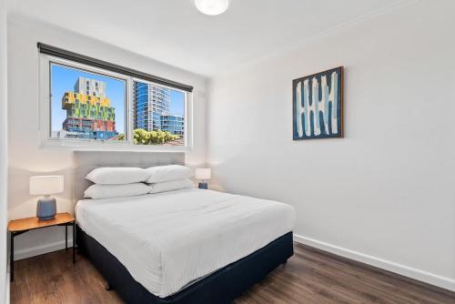 - une chambre blanche avec un lit et une fenêtre dans l'établissement Polished 1-Bed St Kilda Pad in Prime Location, à Melbourne