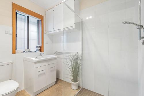 a bathroom with a toilet and a sink and a shower at Spacious 2-Bed Apartment Minutes From Elwood Beach in Melbourne