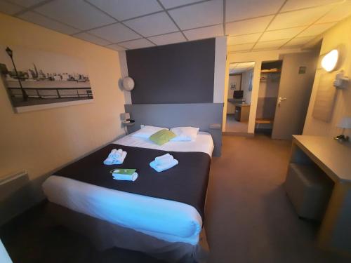 ein Hotelzimmer mit einem Bett mit Handtüchern darauf in der Unterkunft Le Minotel in Vitré