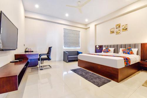 FabHotel Pravaasam Residency في جايبور: غرفة نوم بسرير ومكتب وتلفزيون