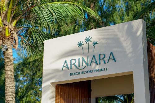 um sinal para um resort de praia com uma palmeira em Arinara Beach Resort Phuket - SHA Extra Plus em Praia de Bang Tao
