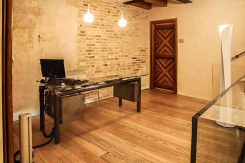 an office with a desk in a room with a brick wall at Locanda Ponte Dante in Treviso