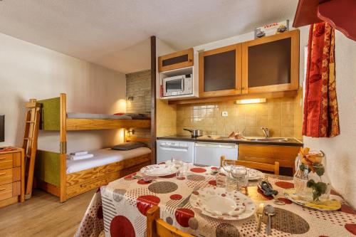Il comprend une petite cuisine avec une table et des lits superposés. dans l'établissement Appartement Lachenal 207 B - Happy Rentals, à Chamonix-Mont-Blanc