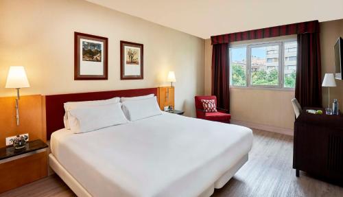 a hotel room with a large bed and a window at NH Ciutat de Reus in Reus