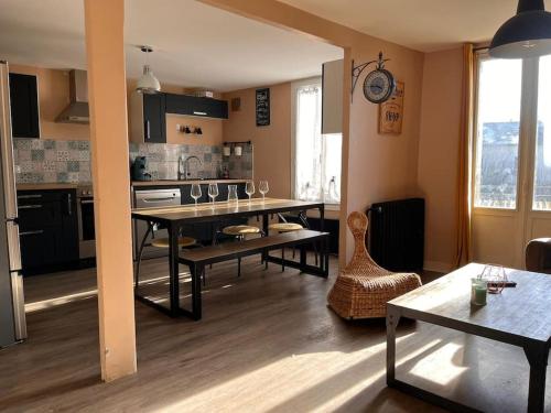 un salon avec une table et une cuisine dans l'établissement Le cozy des tuilières, 2 ch, à Limoges