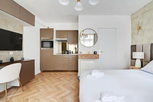 Cet appartement comprend une chambre avec un lit blanc et une cuisine. dans l'établissement le bon plan, à Paris