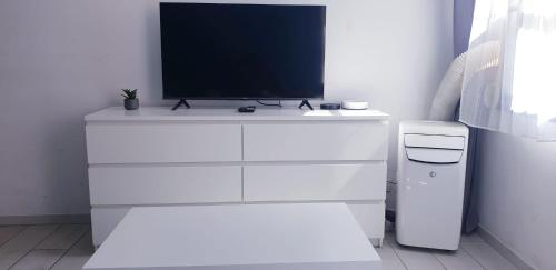- une commode blanche avec une télévision en haut dans l'établissement HYPER Centre-Lumineux-Clim-Wifi, à Toulon