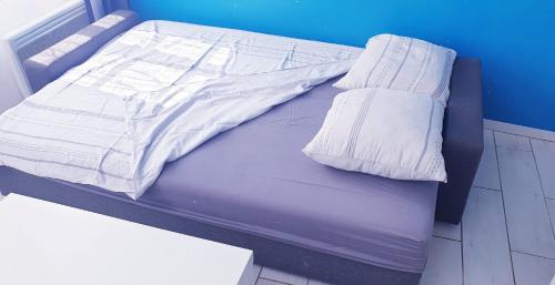 - un lit avec des draps et des oreillers blancs dans l'établissement HYPER Centre-Lumineux-Clim-Wifi, à Toulon