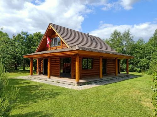 a log cabin with a gambrel roof at Unieke houten villa met SAUNA in Twente - 6p in Den Ham