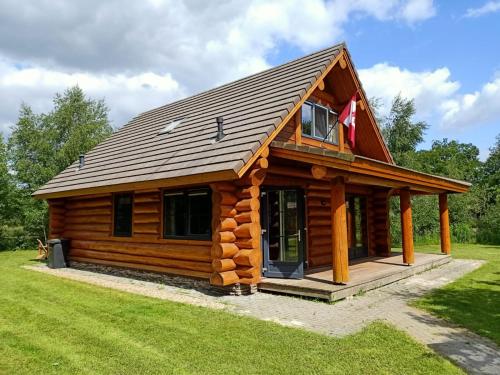 una cabaña de madera con techo de gambrel en Unieke houten villa met SAUNA in Twente - 6p, en Den Ham
