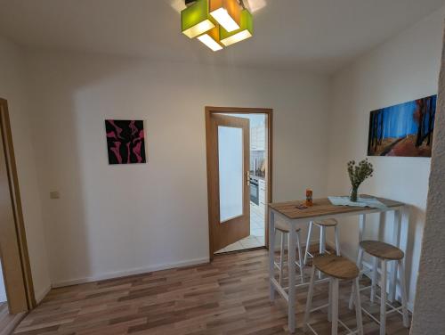 a dining room with a table and stools and a mirror at stylisches Stadtnest am Stadtpark mit modernen Wohngefühl in Wolmirstedt