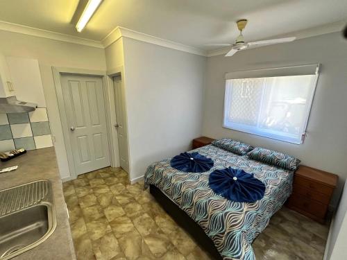 a bedroom with a bed with blue sheets and a sink at Darwin Boomerang Motel and Caravan Park in Howard Springs