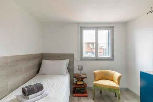 um quarto com uma cama, uma cadeira e uma janela em Attic San Marco for 5 Person - AC - Wifi em Veneza