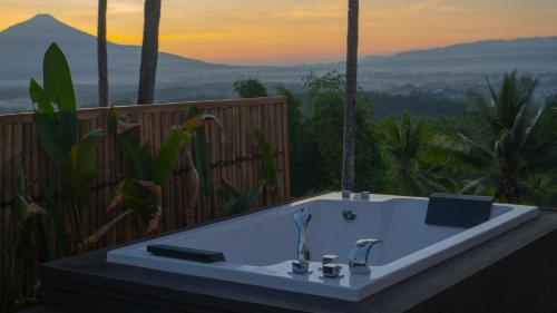 a bath tub with a view of a mountain at Bobocabin Bunaken Hills, Manado in Manado