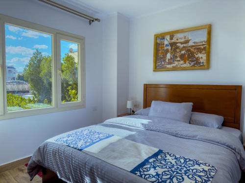 a bedroom with a bed and two windows at Royal Crown Hotel Giza Pyramids View in Cairo