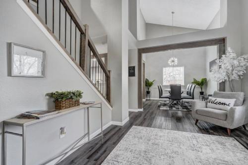 a living room with a staircase and a dining room at Hearth Haven - Hot Tub BBQ Large Groups in Colorado Springs