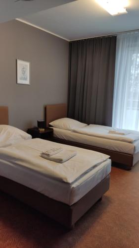 ein Hotelzimmer mit 2 Betten und einem Fenster in der Unterkunft OLIMPIA Ośrodek Przygotowań Sportowych in Rybnik