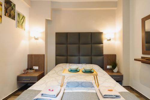 ein Zimmer mit einem Bett und einem Tisch mit Schalen darauf in der Unterkunft Lef Apartment in Thessaloniki