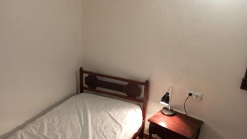 een kleine slaapkamer met een bed en een lamp op een tafel bij Casa Verol C in Moya