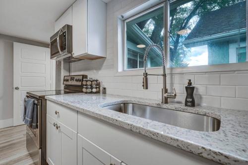 a kitchen with a sink and a window at Institute Charm - Near Hotspots King Sleek Studio in Colorado Springs