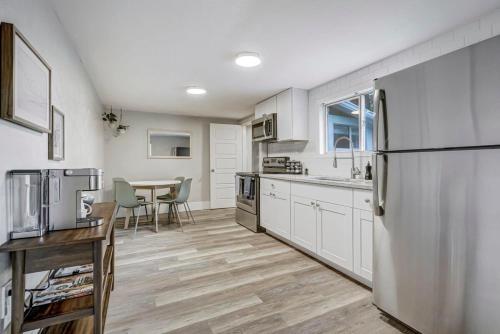 a kitchen with a stainless steel refrigerator and a table at Institute Charm - Near Hotspots King Sleek Studio in Colorado Springs