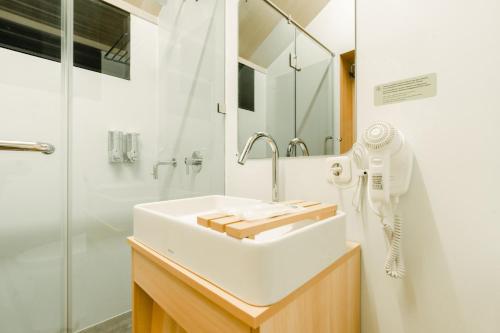 a bathroom with a white sink and a shower at Bobocabin Bunaken Hills, Manado in Manado