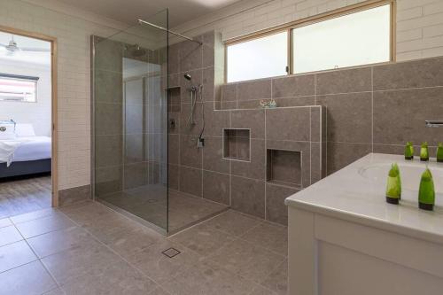 a bathroom with a shower with a glass door at Bella Rose Beach House - 3 BR - 5min to Beach in Agnes Water