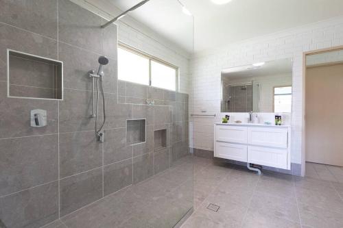a bathroom with a shower and a sink at Bella Rose Beach House - 3 BR - 5min to Beach in Agnes Water