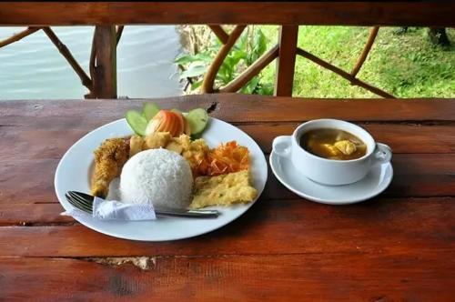 a plate of food with rice and a cup of tea at Camping situ cileunca in Palayangan