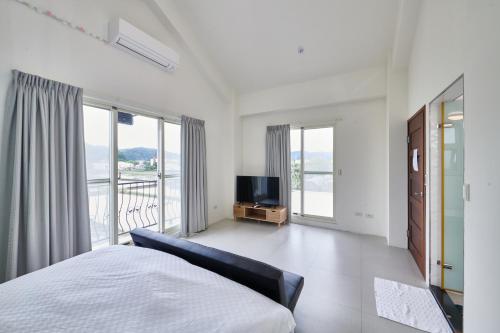 1 dormitorio con 1 cama y TV de pantalla plana en 旅居Villa, en Dongshan