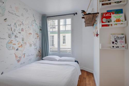 um pequeno quarto com uma cama e uma janela em Paris Trocadero Elegant Residence em Paris