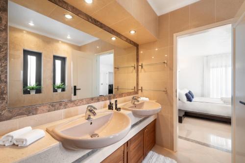 a bathroom with two sinks and a large mirror at Seafront View next to the famous “Benagil Caves” in Benagil